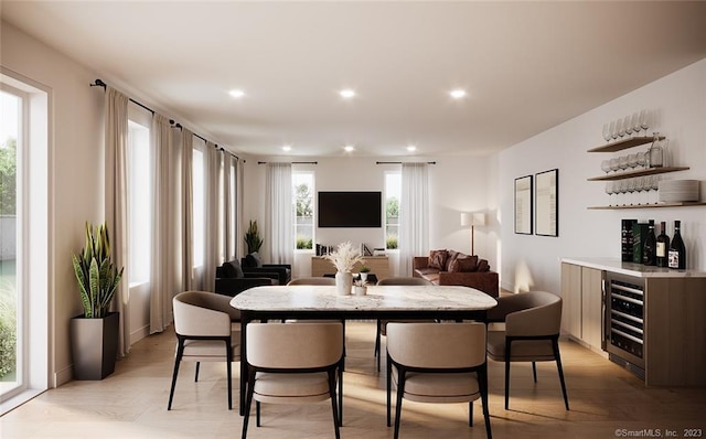 dining space featuring light wood-type flooring, indoor bar, and wine cooler