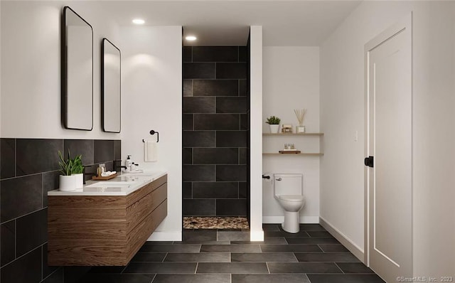 bathroom with tile walls, toilet, double sink vanity, a shower, and tile floors