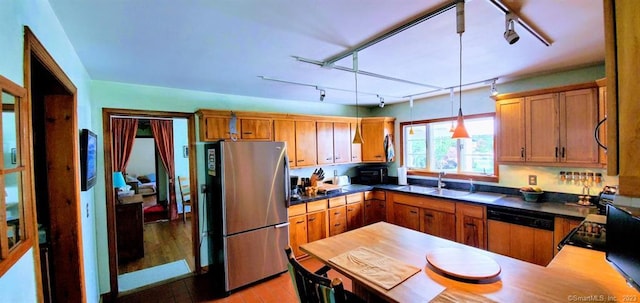 kitchen with stainless steel refrigerator, light hardwood / wood-style flooring, track lighting, pendant lighting, and dishwasher