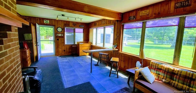 sunroom with plenty of natural light, track lighting, and beamed ceiling