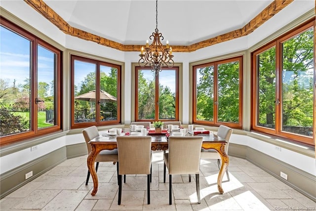 sunroom with an inviting chandelier, plenty of natural light, and a tray ceiling