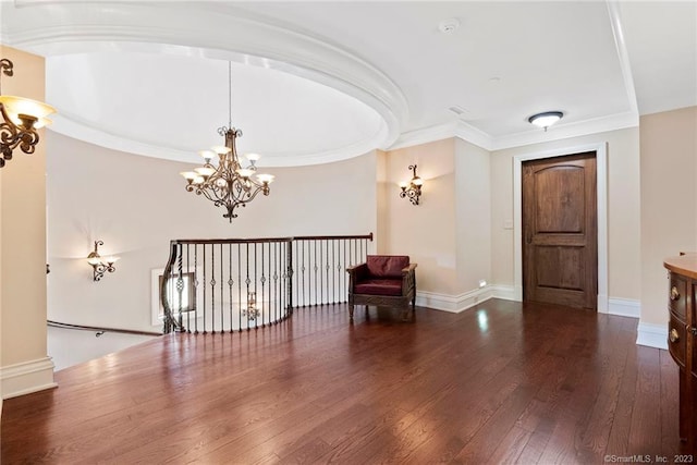 entrance foyer with ornamental molding, an inviting chandelier, and dark hardwood / wood-style flooring