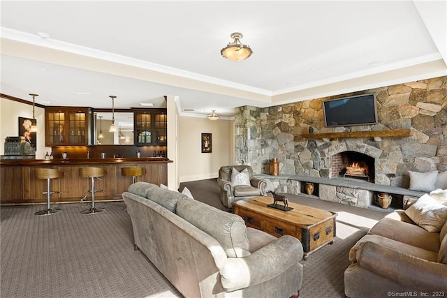 carpeted living room with bar, ornamental molding, and a fireplace