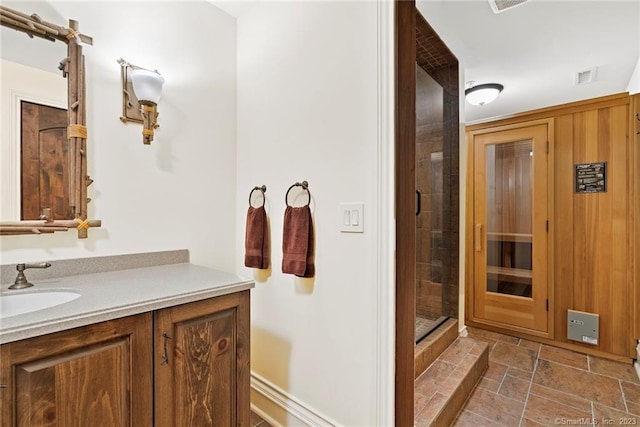 bathroom with a shower with door, tile floors, and vanity with extensive cabinet space