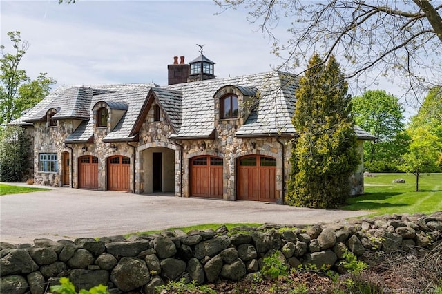 french country style house featuring a front yard and a garage