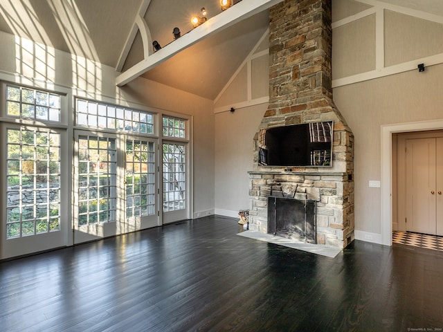 unfurnished living room with beamed ceiling, dark hardwood / wood-style floors, high vaulted ceiling, and a fireplace