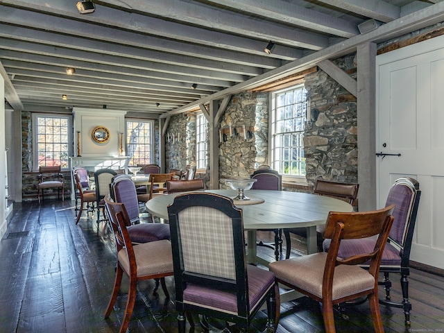 dining area with beamed ceiling and dark hardwood / wood-style flooring