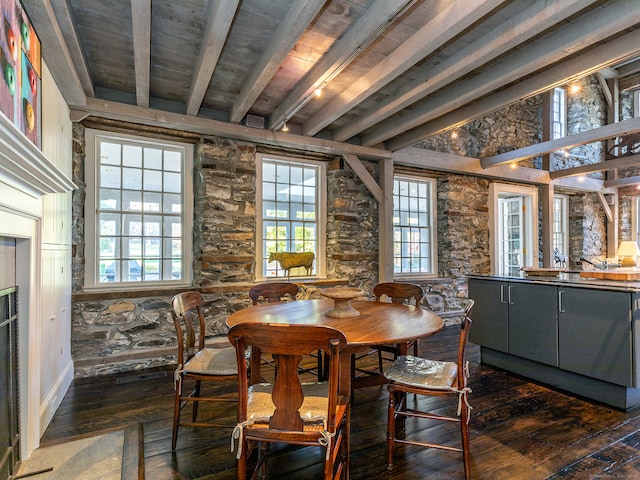 dining space with beamed ceiling and dark wood-type flooring