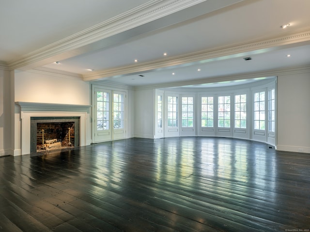 unfurnished living room with dark wood-type flooring, crown molding, and a healthy amount of sunlight