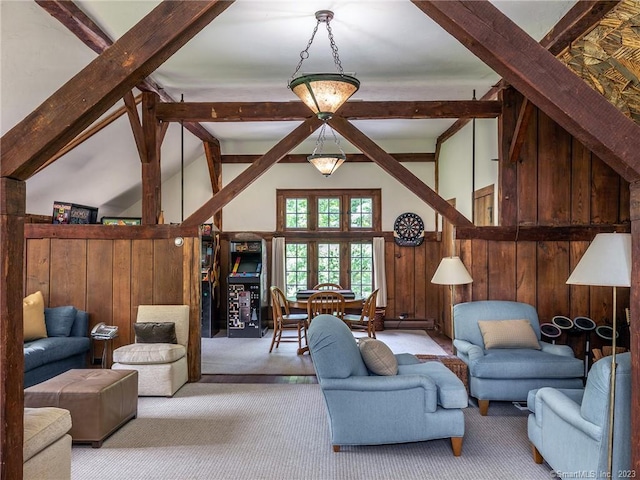 carpeted living room with wood walls, beam ceiling, and high vaulted ceiling