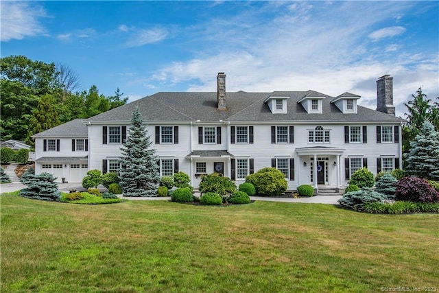 rear view of property featuring a yard and a garage