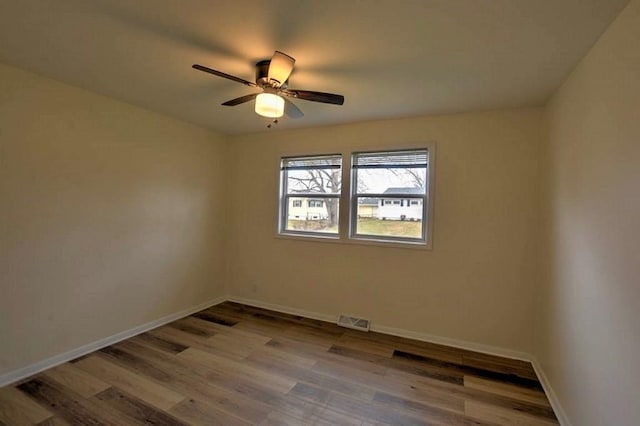 spare room with ceiling fan and light wood-type flooring