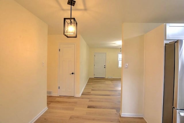 corridor with light hardwood / wood-style flooring