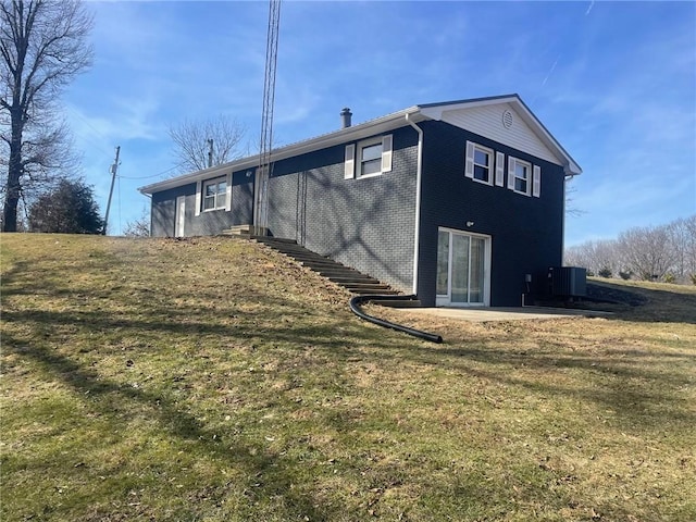 back of property with cooling unit, a lawn, and a patio