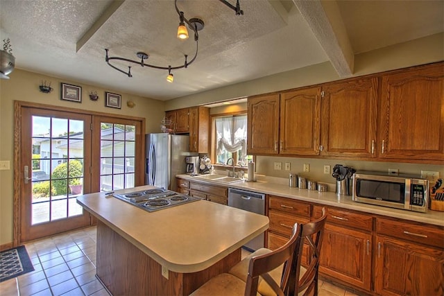 220 W Main St, Mt Zion, IL 62549 - kitchen with appliances with stainless steel finishes, brown cabinets, light tile patterned floors, healthy amount of natural light, and a textured ceiling