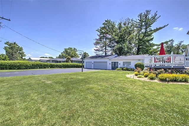 220 W Main St, Mt Zion, IL 62549 - view of grassy yard featuring driveway, an attached garage, and a deck