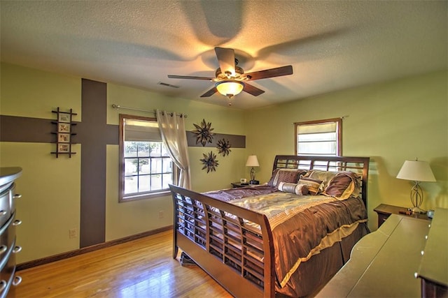 220 W Main St, Mt Zion, IL 62549 - bedroom with multiple windows, wood finished floors, a textured ceiling, and ceiling fan