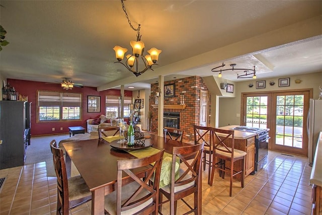 220 W Main St, Mt Zion, IL 62549 - dining area with light tile patterned floors, a fireplace, a chandelier, and a ceiling fan