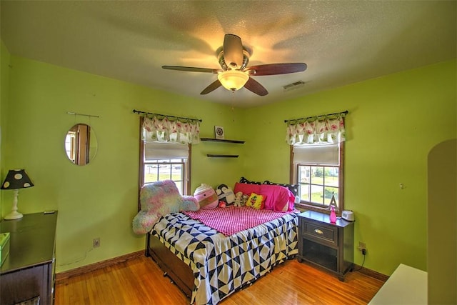 220 W Main St, Mt Zion, IL 62549 - bedroom featuring multiple windows, wood finished floors, a ceiling fan, and arched walkways