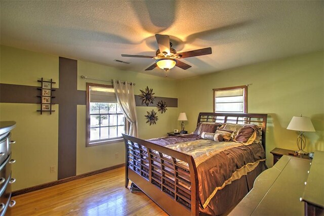220 W Main St, Mt Zion, IL 62549 - bedroom with multiple windows, wood finished floors, a textured ceiling, and a ceiling fan