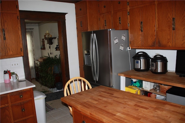 kitchen with decorative backsplash, stainless steel fridge, and light tile patterned floors