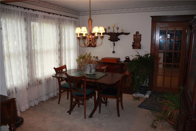 carpeted dining room featuring an inviting chandelier