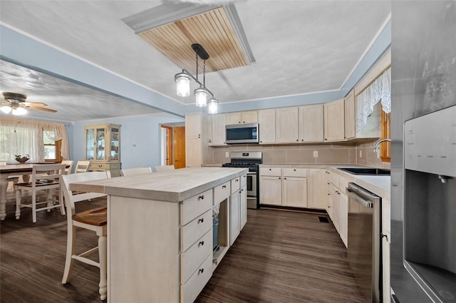 705 Adams Ave, Casey, IL 62420 - kitchen featuring stainless steel appliances, light countertops, ceiling fan, dark wood-style flooring, and a kitchen island