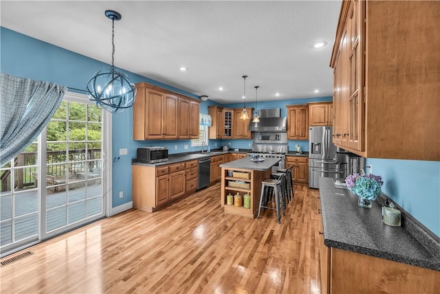 1435 Ashland Ave, Mt Zion, IL 62549 - kitchen with appliances with stainless steel finishes, wall chimney range hood, a center island, dark countertops, and recessed lighting