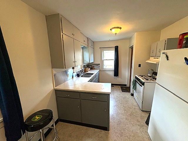 609 S 2nd St, Effingham, IL 62401 - kitchen with white appliances, a sink, under cabinet range hood, light countertops, and gray cabinetry