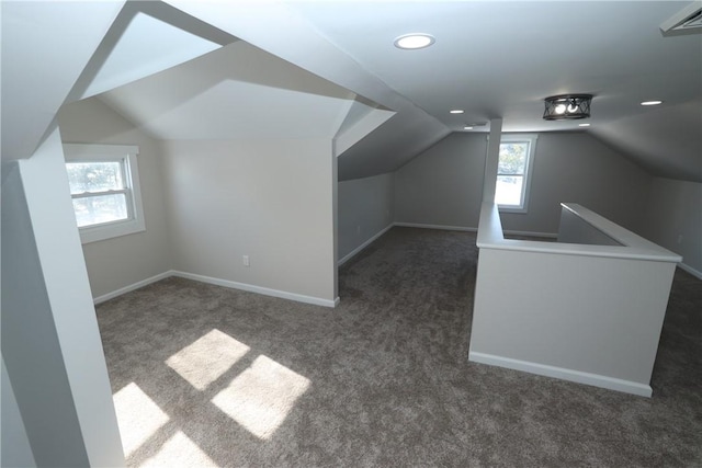 bonus room featuring lofted ceiling and dark carpet