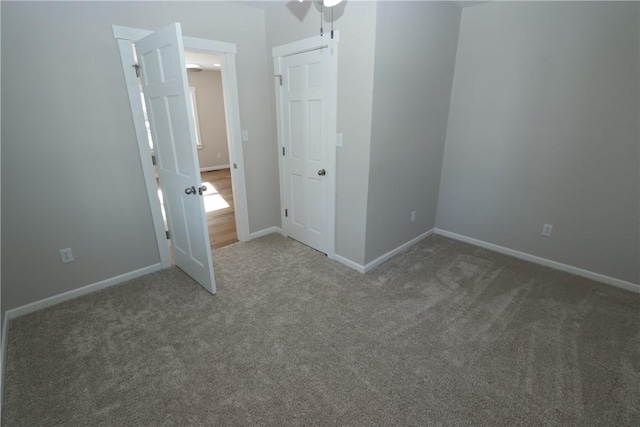 unfurnished bedroom with ceiling fan and dark colored carpet