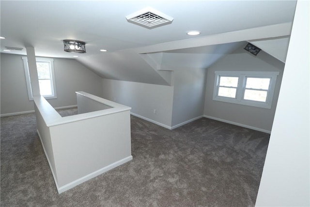 bonus room with dark carpet and lofted ceiling