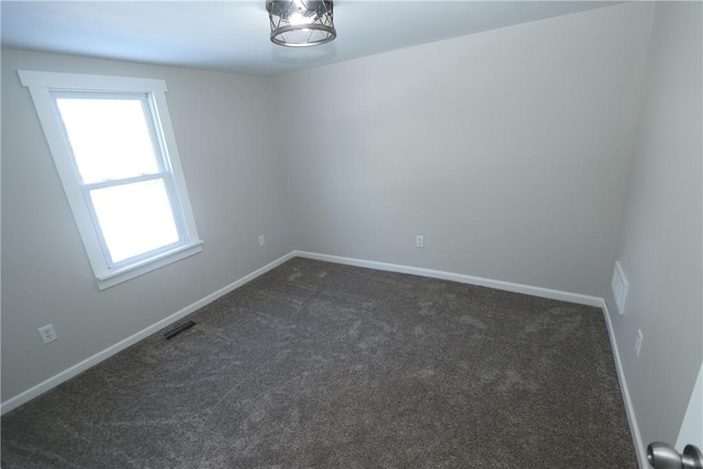 spare room with dark colored carpet