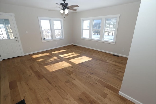 interior space with a wealth of natural light, ceiling fan, and hardwood / wood-style flooring