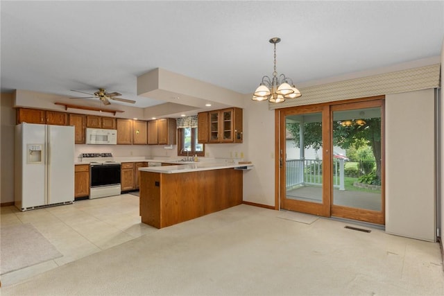 2104 Sycamore St, Effingham, IL 62401 - kitchen with white appliances, brown cabinetry, a peninsula, a chandelier, and light countertops