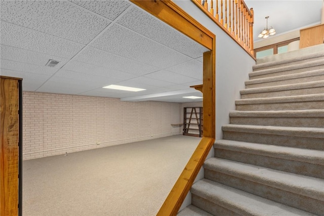2104 Sycamore St, Effingham, IL 62401 - stairs featuring brick wall, a drop ceiling, carpet flooring, and a chandelier
