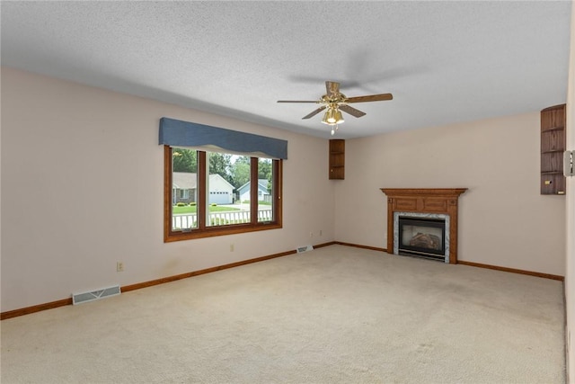 2104 Sycamore St, Effingham, IL 62401 - unfurnished living room featuring carpet flooring, ceiling fan, a glass covered fireplace, and a textured ceiling