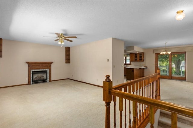 2104 Sycamore St, Effingham, IL 62401 - unfurnished living room with light colored carpet, a chandelier, ceiling fan, and a glass covered fireplace
