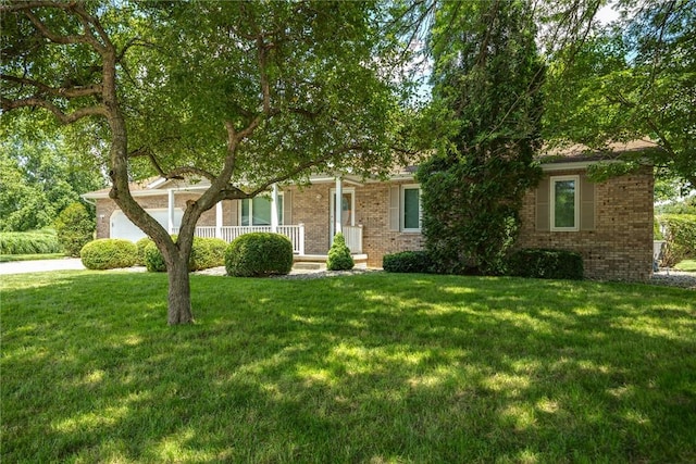 2104 Sycamore St, Effingham, IL 62401 - view of property hidden behind natural elements featuring brick siding, a front lawn, covered porch, and an attached garage
