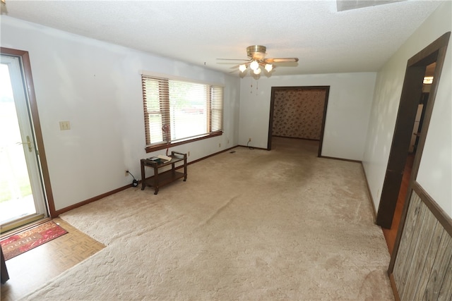 carpeted spare room featuring ceiling fan and a textured ceiling