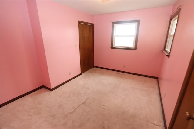 spare room featuring light carpet