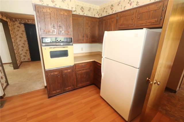 kitchen featuring light wood-type flooring and white appliances