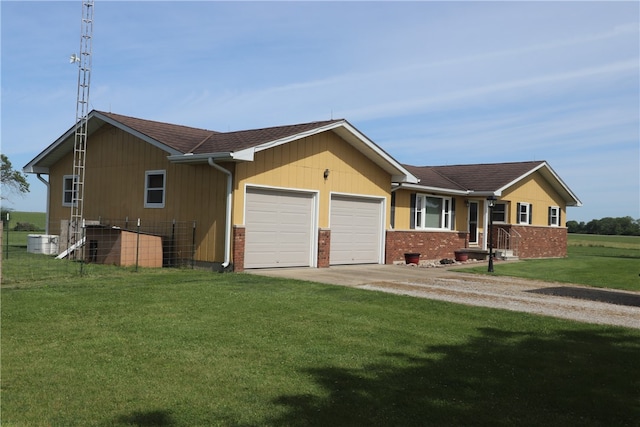 ranch-style house with cooling unit, a front yard, and a garage