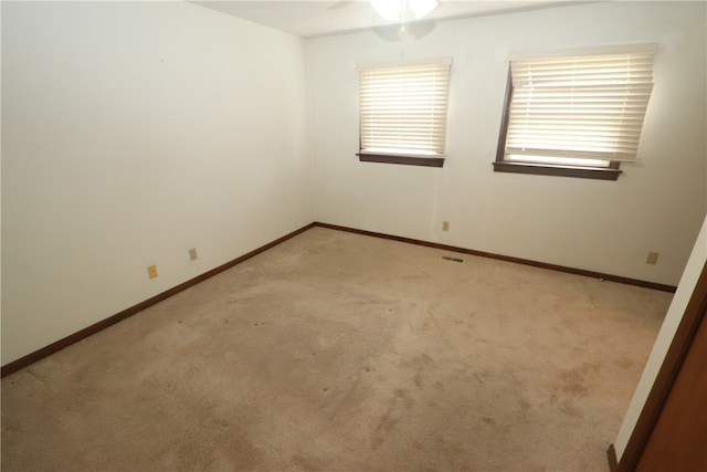 carpeted spare room with ceiling fan