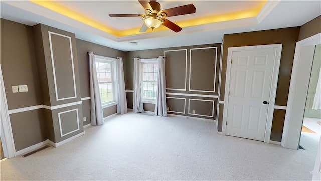 112 N 3rd St, Hoopeston, IL 60942 - unfurnished bedroom featuring a tray ceiling, carpet, ceiling fan, and baseboards