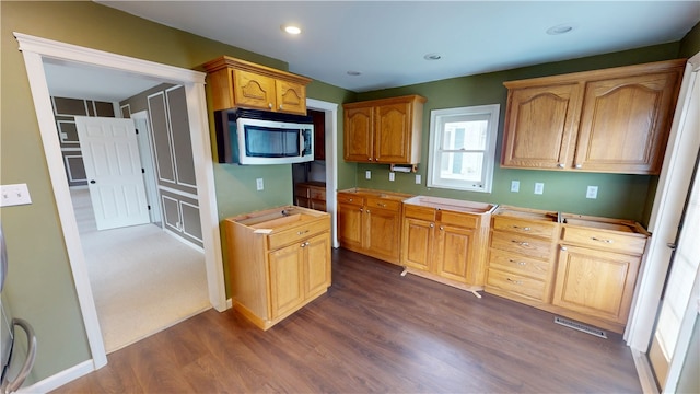 112 N 3rd St, Hoopeston, IL 60942 - kitchen featuring stainless steel microwave, dark wood-style floors, light countertops, and recessed lighting