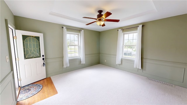 112 N 3rd St, Hoopeston, IL 60942 - foyer with plenty of natural light, a raised ceiling, a ceiling fan, and wainscoting