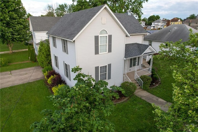 112 N 3rd St, Hoopeston, IL 60942 - view of front of property featuring roof with shingles, a front lawn, and covered porch