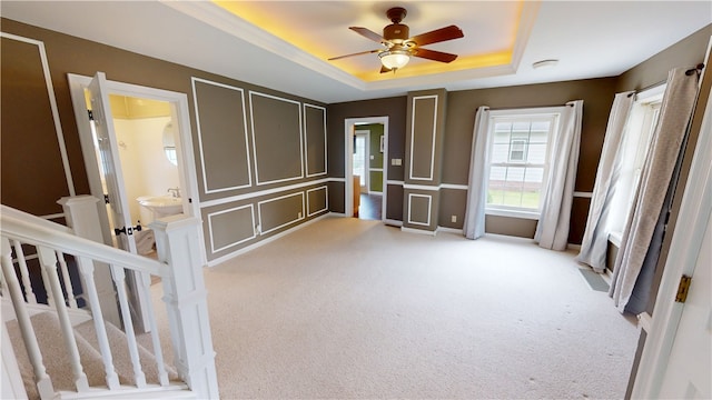 112 N 3rd St, Hoopeston, IL 60942 - spare room with light colored carpet, a tray ceiling, and ceiling fan