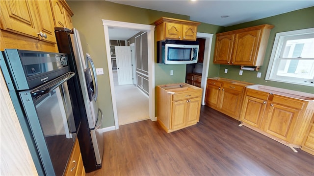 112 N 3rd St, Hoopeston, IL 60942 - kitchen featuring stainless steel microwave, oven, dark wood finished floors, light countertops, and brown cabinetry